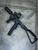 Custom TX22 chassis with folding brace, suppressor, and red dot optic mounted, shown on concrete floor. Lightweight polymer chassis designed for enhanced stability, optic mounting, and modular accessories for the Taurus TX22 platform.