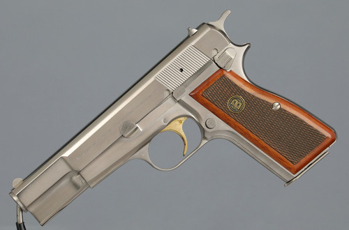 Belgian Browning High-Power pistol with stainless finish and walnut grip.