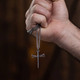 Shields of Strength Stainless Steel Gold Plated Nail Cross Necklace-John 19:30  Man's hand holding the necklace