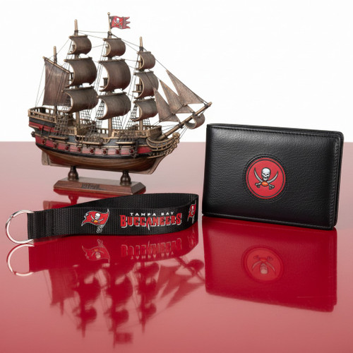 Tampa Bay Buccaneers Football Lanyard Wristlet Keychain - Displayed on a red table next to a black wallet and a miniature pirate ship in the background