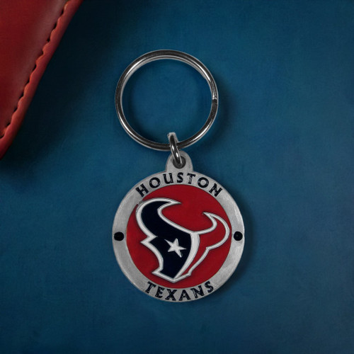 Houston Texans NFL Round Metal Logo & Wordmark Keychain - On a Texans Blue Table next to a wallet