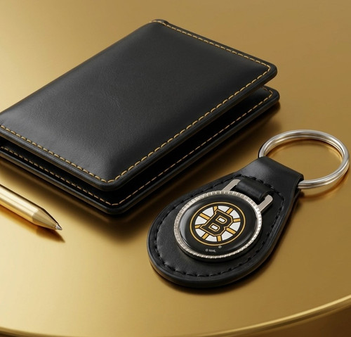 Boston Bruins NHL Black Leather Key Fob Keychain - Displayed on a yellow gold color table, next to a black wallet