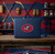 Columbus Blue Jackets Hockey Red, White & Blue 3.25 Inch Logo Emblem - Displayed on the back of a blue laptop in a hockey themed room.