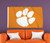Clemson University NCAA Orange Tiger Paw Logo Flag - Indoors - Hanging on a wall above an orange couch