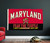 University Of Maryland NCAA Fear The Turtle Flag - Displayed indoors hanging on a wall in a sports fan room.