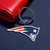 New England Patriots NFL Rubber Logo Keychain - On a Patriots blue color table next to a red wallet