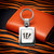 Cincinnati Bengals Football Laser Etched Logo Keychain - Square - Displayed on a tiger striped table next to an orange wallet
