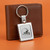 Cleveland Browns NFL Square Laser Etched Helmet Logo Keychain - Displayed on an orange table next to a brown wallet.