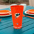 Miami Dolphins NFL Orange Insulated Tumbler – 20 oz – Shatter‑Proof Acrylic - displayed on an aqua table with orange and white plates and cups