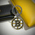 Boston Bruins NHL Enameled Chrome Logo Keychain - On a table next to a gold and black wallet