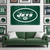 New York Jets Football Wall Banner Flag – Embroidered Logo - Indoors - Hanging On a white wall Above a Jets Green Color Couch in a football fan cave room
