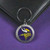 Minnesota Vikings NFL Round Metal Logo & Wordmark Keychain - On a Vikings Purple color table next to a wallet
