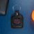 Auburn Tigers NCAA Black Fob Keychain - on a blue table next to a black wallet