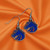 Boise State Broncos NCAA Chrome Dangle Logo Earrings – Lightweight Fashion Earrings with Detailed Team Charm - Displayed on orange silk fabric