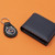 Chicago Bears Football Keychain - Black Leather Fob Logo Key Chain - Displayed on an orange table next to a navy blue wallet