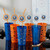 Six New York Islanders curly straws in blue and orange hockey-themed tumblers on a shiny black table with pucks and sticks.
