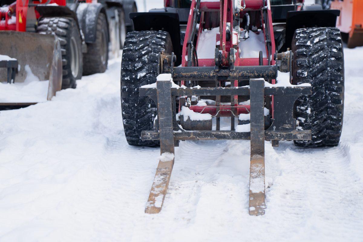 Rough terrain forklift with deep-lug pneumatic tires operating in deep snow