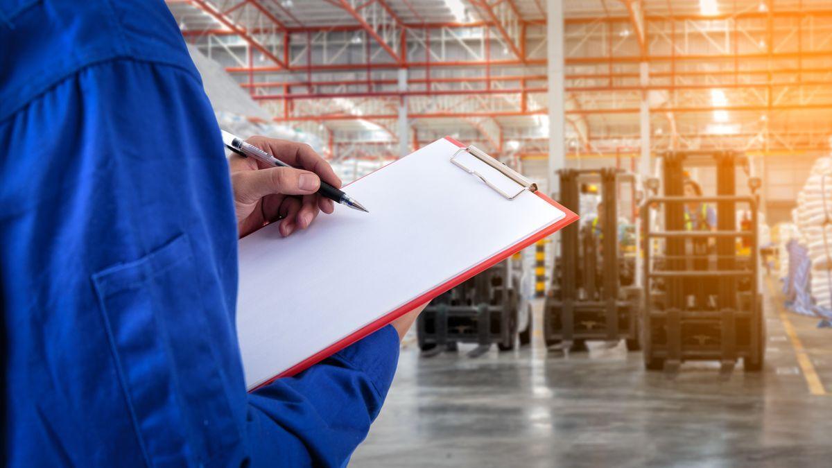 Warehouse worker with clipboard inspecting forklifts — forklift tire buying guide