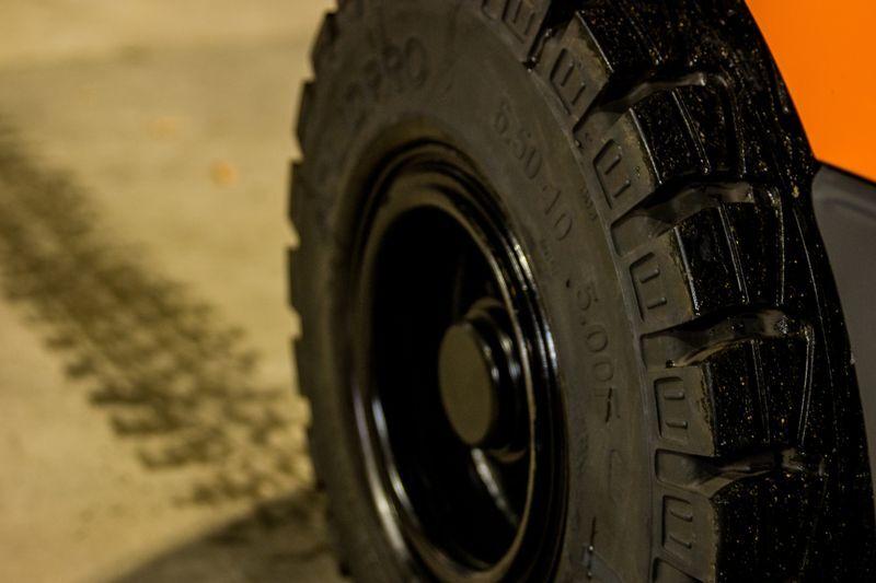 Forklift wheel close-up showing tire size markings on sidewall