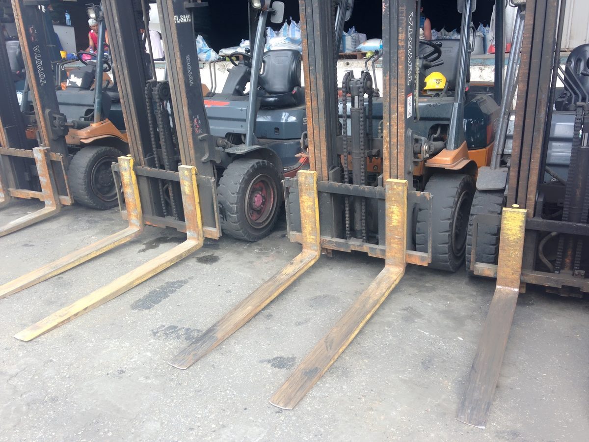 Row of Toyota pneumatic-tire forklifts showing drive tires and forks