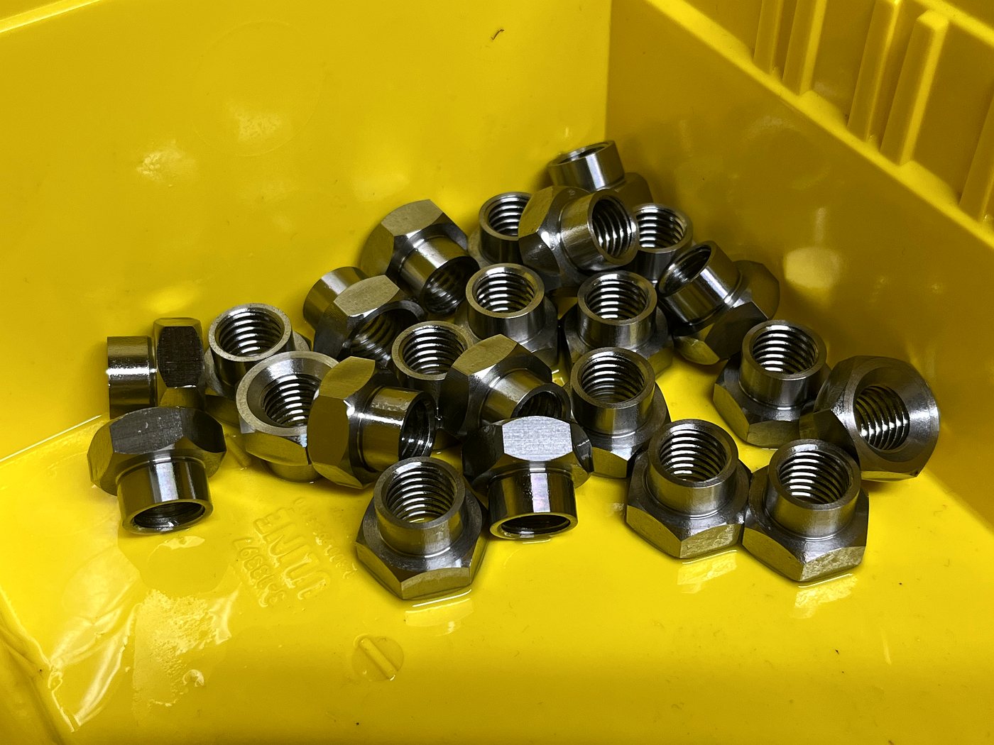 Machined hex nuts in a parts bin