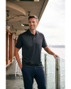 Man standing on a balcony while wearing a Black Cutter & Buck Prospect Eco Textured Stretch Recycled Mens Short Sleeve Polo Thumbnail Image