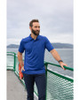 A man standing by water while wearing a Tour Blue Cutter & Buck Prospect Eco Textured Stretch Recycled Mens Short Sleeve Polo