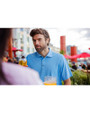 A man having a drink while wearing an Atlas Cutter & Buck Virtue Eco Pique Recycled Mens Polo