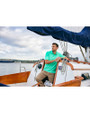 A man on a boat while wearing a Fresh Mint Cutter & Buck Virtue Eco Pique Recycled Mens Polo