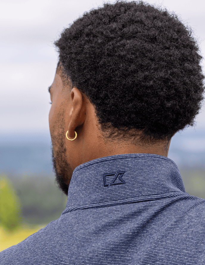 Man looking away wearing an Adapt Stripe quarter zip.