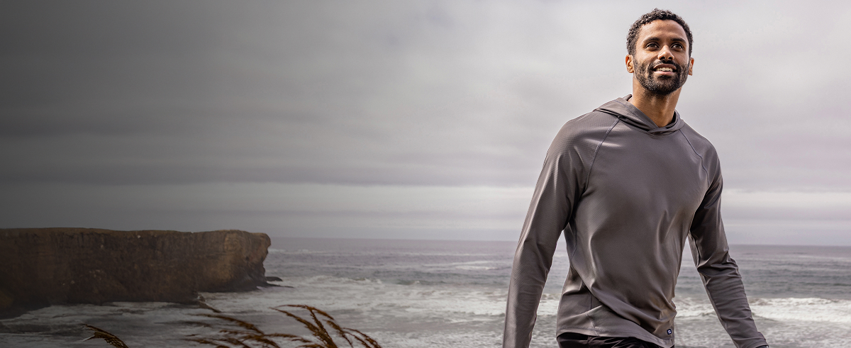 Man walking on beach wearing Cutter & Buck jackets and layers.