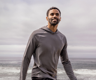 Man walking on beach wearing Cutter & Buck jackets and layers.