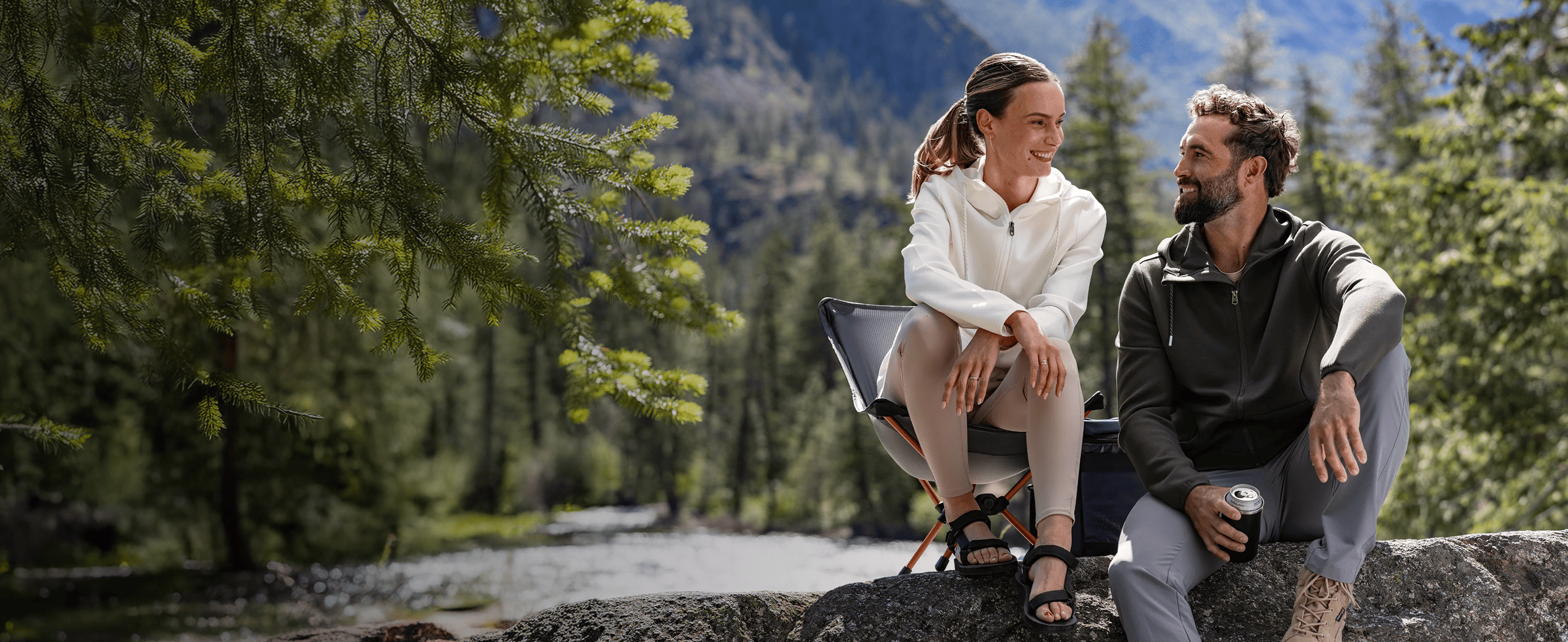 Man and woman in a mountain landscape wearing Cutter & Buck sweatshirts.
