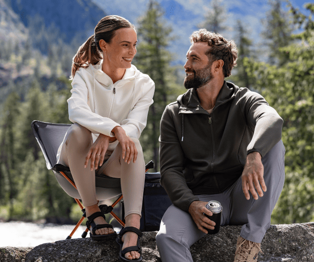 Man and woman in a mountain landscape wearing Cutter & Buck sweatshirts.