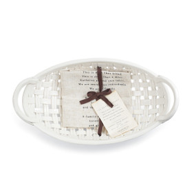 White bread basket bowl with cream towel that is tied with brown bow in the middle