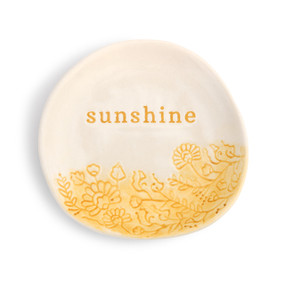 A small round cream and yellow trinket dish that says "sunshine" with flowers at the bottom.