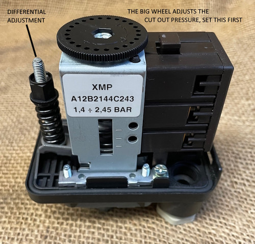 Side view of the Telemecanique XMPA12B21442 pressure switch showing the main adjustment wheel and the smaller adjustment for the differential with labels. Side view of the Telemecanique XMPA12B21442 pressure switch showing the main adjustment wheel and the smaller adjustment for the differential with labels.