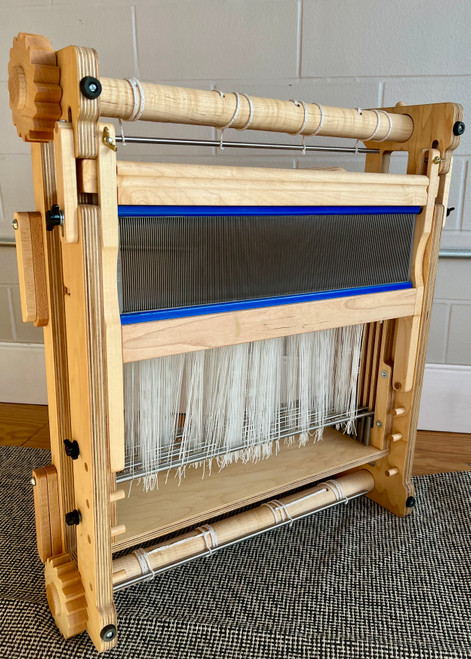 16" tabletop weaving loom made from hardwood with adjustable tension system, compact frame, and portable design for studio or classroom weaving. Beater stowed beneath loom using Beater Locks.