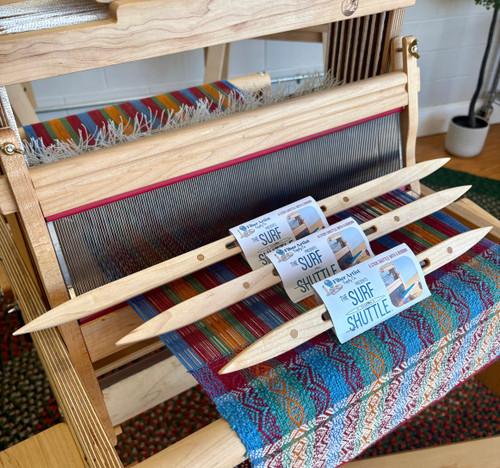 Maple Surf Shuttle by Fiber Artist Supply Co., handcrafted from solid hard maple and designed for smooth, efficient weaving on rigid heddle, table, and frame looms. This lightweight wooden weaving shuttle features an open slot design and removable bobbin for easy loading and fast yarn delivery.