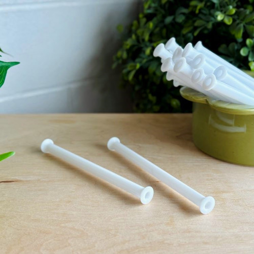 Plastic weaving bobbin, lightweight and durable, with a hollow core for shuttles or bobbin winders. Smooth, flared edges hold yarn securely for weaving projects.