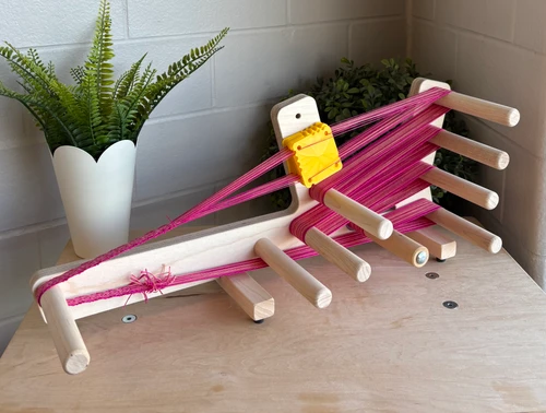 Compact inkle loom made from durable hardwood, ideal for weaving straps, belts, trims, and friendship bands with even tension and easy warping.