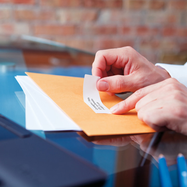 Hand applying an address label to a cardboard box