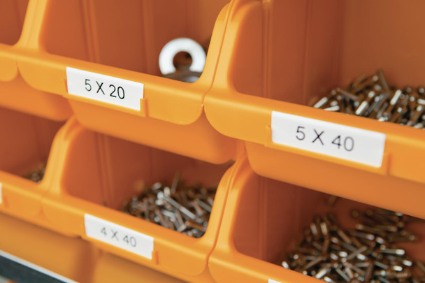 DYMO Rhino white on black label wrapped around thick orange electrical wire in industrial setting