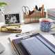 Organised office desk with labelled stationery holders, clipboard, notebook and stapler for personalised workspace organisation