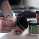 Hands applying a DYMO LetraTag label to a kitchen storage jar