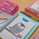 Colourful school and office supplies labelled with yellow LetraTag plastic tape