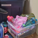 Lost and found storage bin with labelled clothing and drink bottles ready to return to cabins