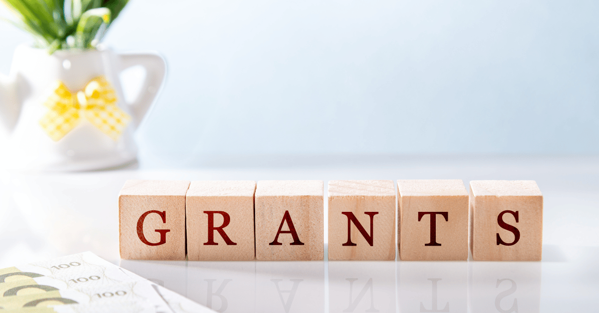 Grant application binders and financial documents on a desk, representing small business grant funding opportunities and financial support for vending entrepreneurs