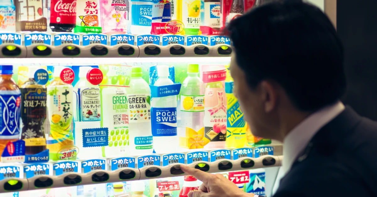 Customer selecting beverages from a vending machine with a product mix tailored to the location's needs