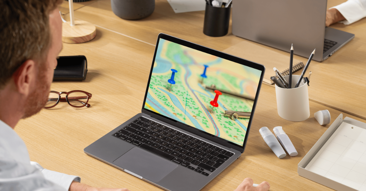 Business professional planning vending machine route locations on a laptop map
